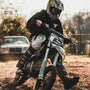 man riding on black and green motocross dirt bike