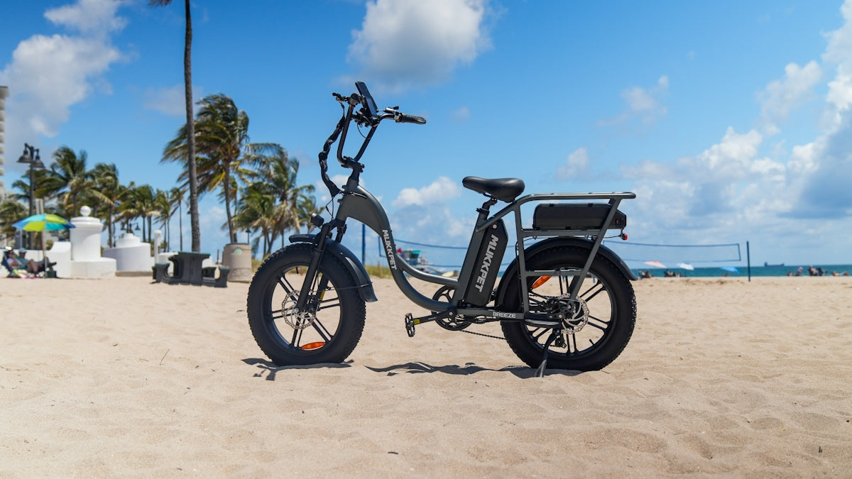 An electric bike parked on a beach near palm trees