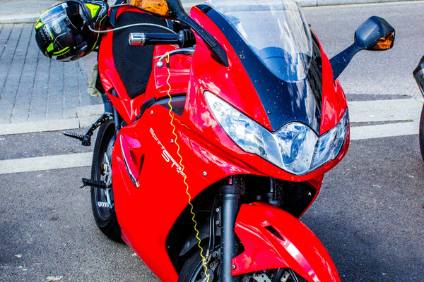 A red motorcycle parked on the side of the road