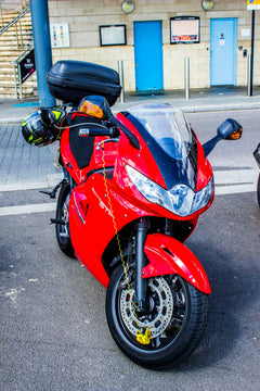 A red motorcycle parked on the side of the road