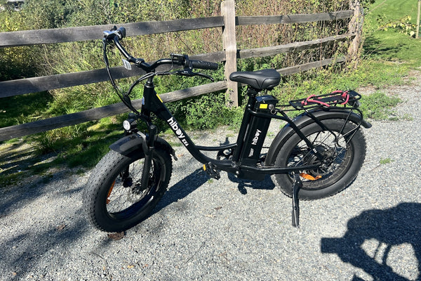 A black bike parked next to a wooden fence