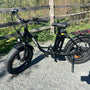 A black bike parked next to a wooden fence