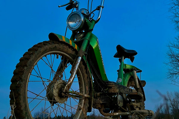 A green dirt bike parked in a field