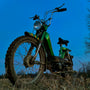 A green dirt bike parked in a field
