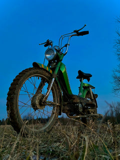 A green dirt bike parked in a field