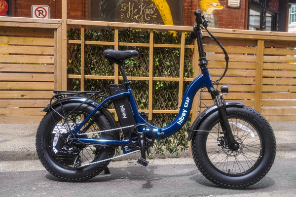 An electric bike is parked on the sidewalk.