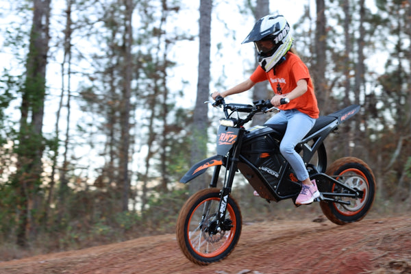 Woman riding a dirt bike on a trail